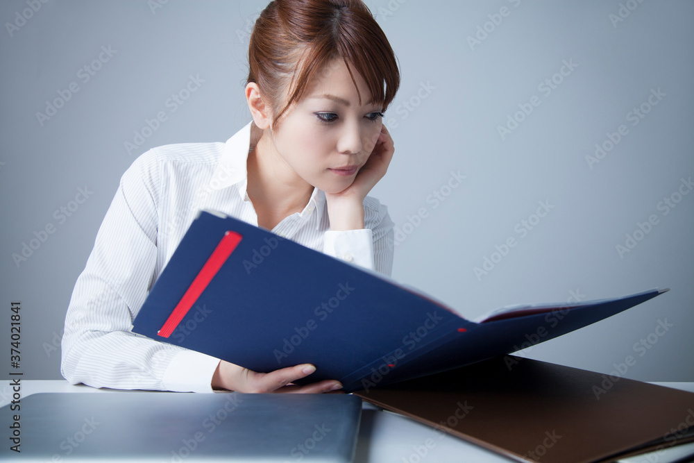 資料を見て悩むOL 資料を見て悩むOL