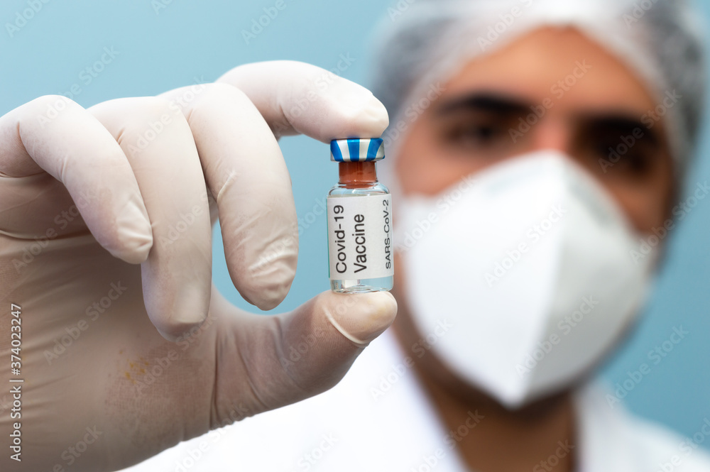 Scientist holding covid vaccine bottle Scientist holding covid vaccine bottle