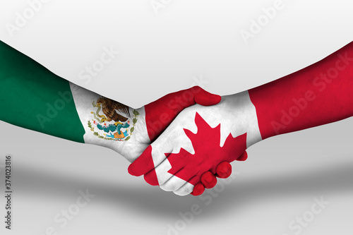 Photography Handshake between canada and mexico flags painted on hands, illustration with clipping path