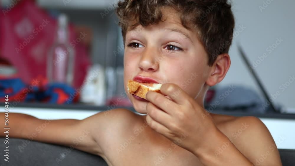Pensive preteen boy eating piece of bread Pensive preteen boy eating piece of bread
