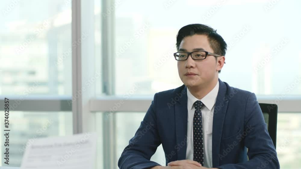 young asian business man being interviewed by HR manager in modern corporation, zooming out