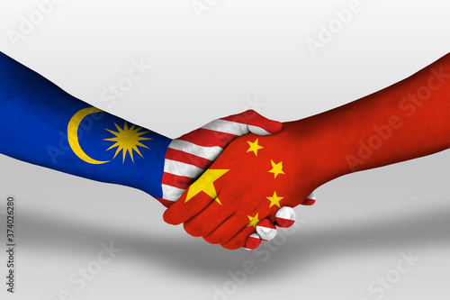 Photography Handshake between china and malaysia flags painted on hands, illustration with clipping path