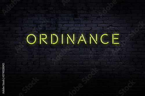 Photos Neon sign. Word ordinance against brick wall. Night view