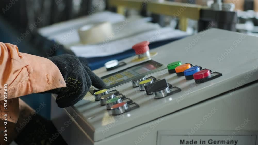 Man working on the control panel works with an industrial machine at the factory close-up. Man working on the control panel works with an industrial machine at the factory close-up.