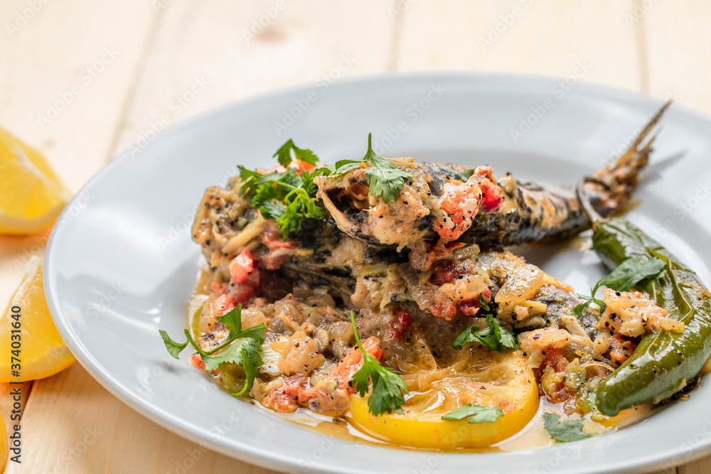 Sardine dinner plate cooked with chopped tomato, garlic sauce, and caramelized onions. Sardine dinner plate cooked with chopped tomato, garlic sauce, and caramelized onions.