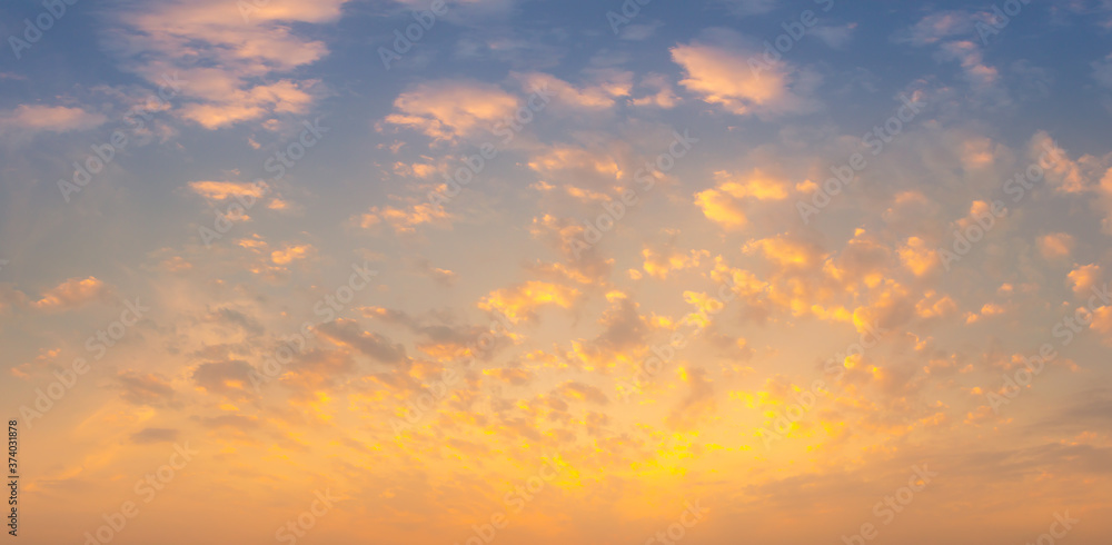 Obraz premium Beautiful Vivid sky painted by the sun leaving bright golden shades.Dense clouds in twilight sky in winter evening.Image of cloud sky on evening time.Evening Vivid sky with clouds.