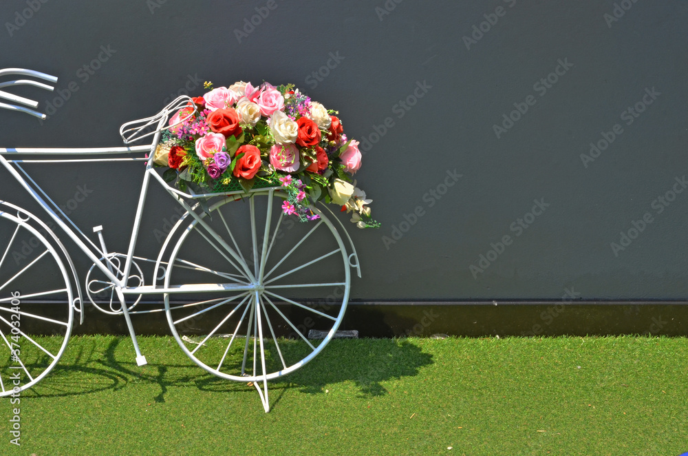 Φωτογραφία Beautiful flowers on pillion of white bicycle beside the wall