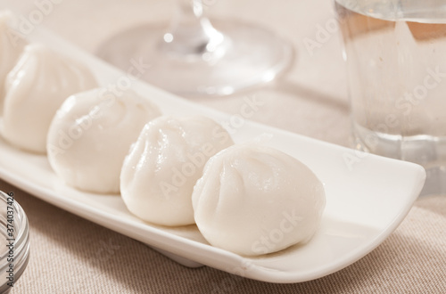 Dim sum dumplings with soy sauce on white plate