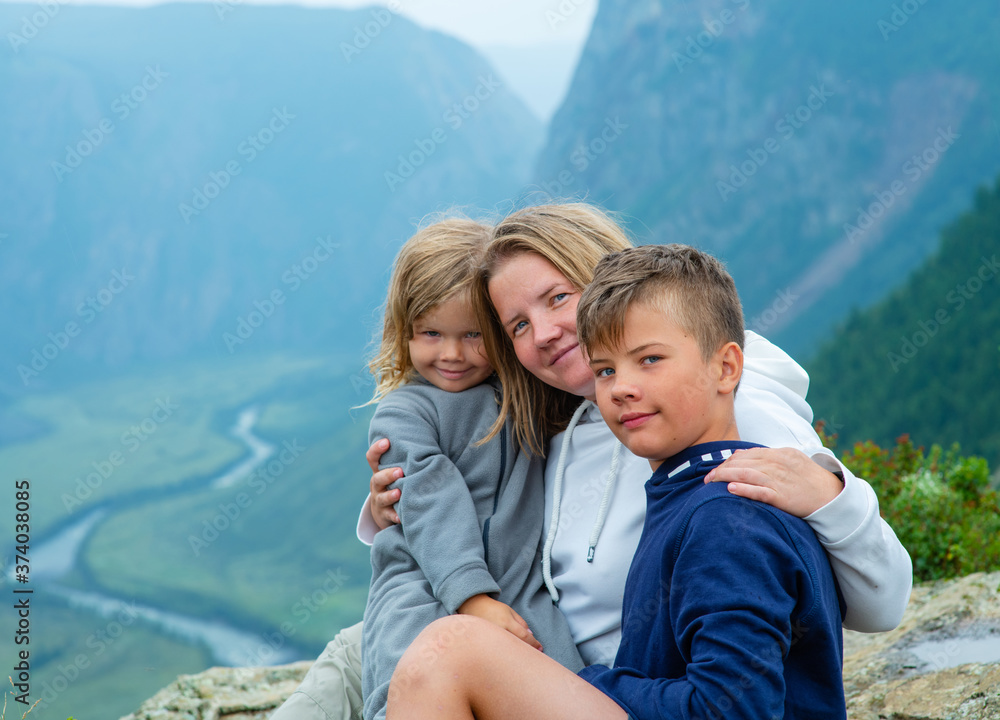 Friendly happy family against the background of the mountains and the valley of the chulyshman river in the mountains of the republic of altai Friendly happy family against the background of the mountains and the valley of the chulyshman river in the mountains of the republic of altai