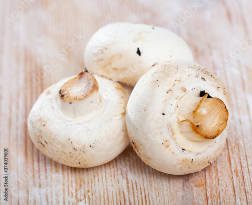 Raw champignons on wooden table, ingredients for cooking