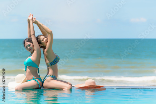 Selective focus, Group of cheerful young women enjoying summertime together in the swimming poo,Beautiful hot pretty girls in bikini are swimming in a pool. © chartphoto