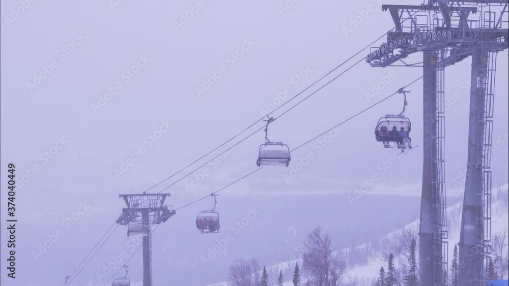 people in warm suits ride poma lift sitting in cabins over snowy slope while heavy mist coming on nasty winter day timelapse people in warm suits ride poma lift sitting in cabins over snowy slope while heavy mist coming on nasty winter day timelapse