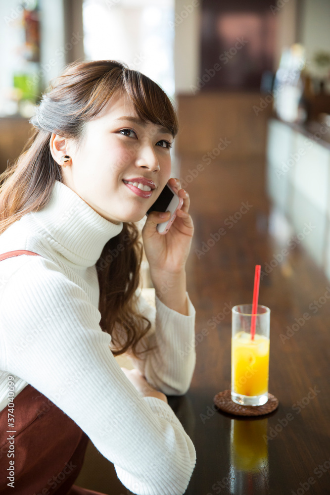 カフェで電話をする女性 カフェで電話をする女性