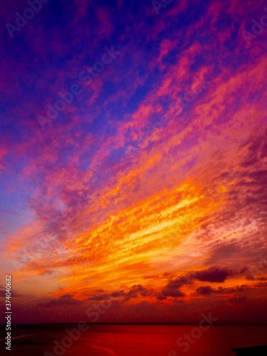 石垣島の海をオレンジ色に染める夕焼け雲。 © 正人 萩谷