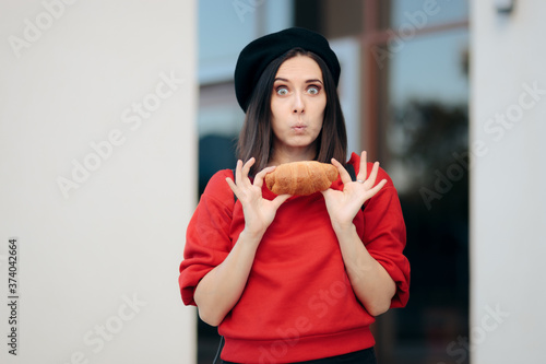 Tableau sur toile Funny Female Tourist Eating a Croissant Outdoors