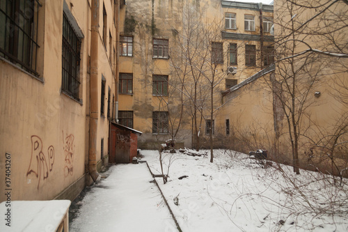 The courtyard of an old apartment building in St. Petersburg with yellow shabby walls © Дэн Едрышов