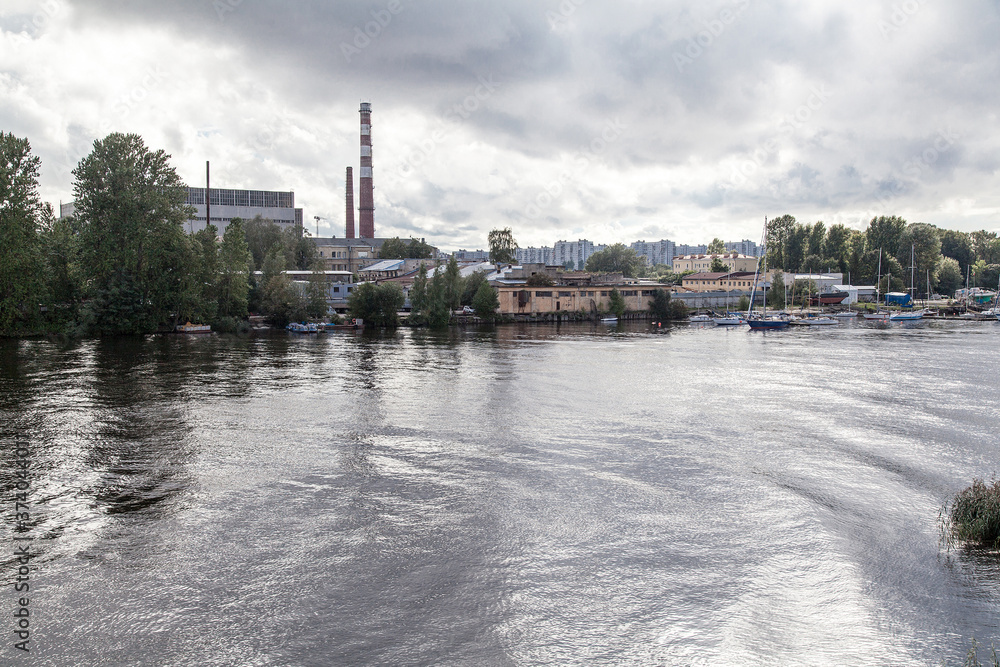 River cityscape with old factory in sunny day