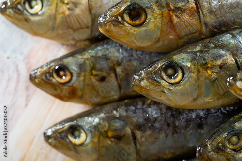 Closeup of stack of salted sardines on wooden background..