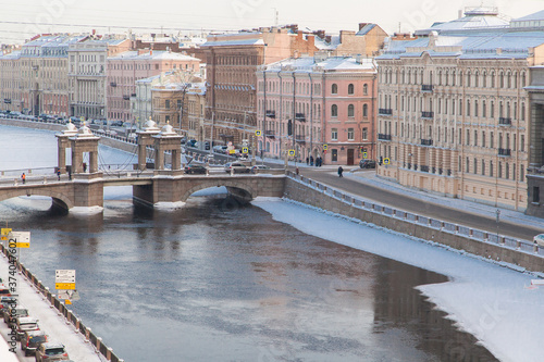 Winter cityscape of St. Petersburg with the freezing Fontanka river and a view of the Lomonosov bridge