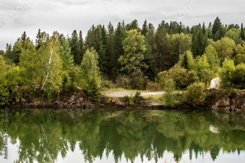 Fototapeta Naklejka Na Ścianę i Meble -  Stunning photo of fall foliage reflected on a lake with a glass like mirror water surface