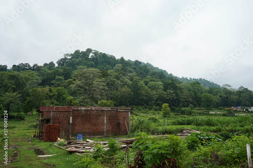 a house being constructed with red bricks in between mountain range.