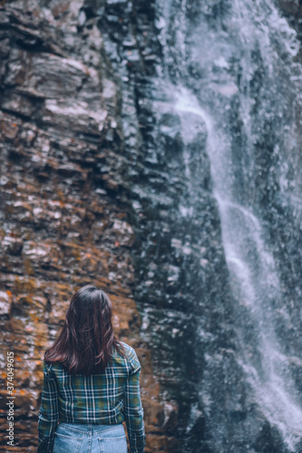 woman in casual clothes looking at waterfall