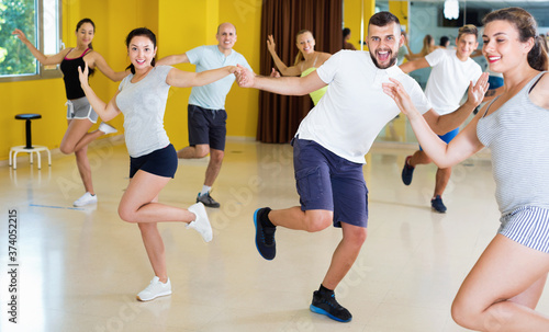 Merry happy cheerful positive couples dancing in studio and smiling