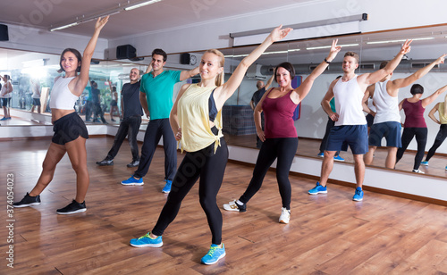 Young people learning zumba steps in dance hall
