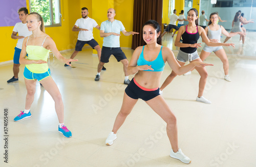 People are learning zumba movements in dance class.