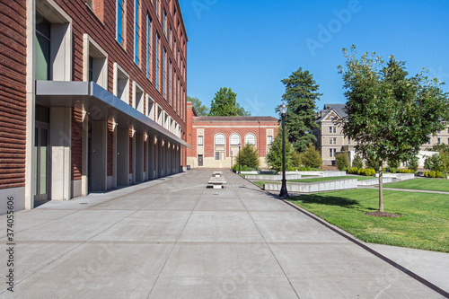 Public university campus on sunny day showing new and old architecture and open spaces with no college students present.

