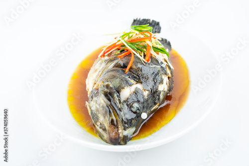 A dish of Cantonese steamed grouper on white background