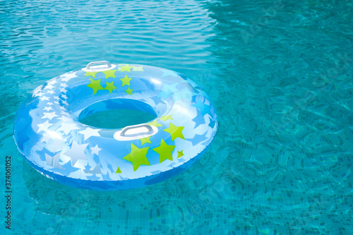 Ring floating in a refreshing blue swimming pool. Kids toys. Inflatable rubber circle floating in clear blue water.