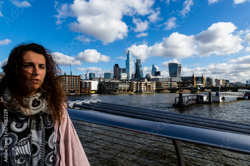 giovane ragazza a Londra pensa con dietro lo sfondo della città e il fiume photo