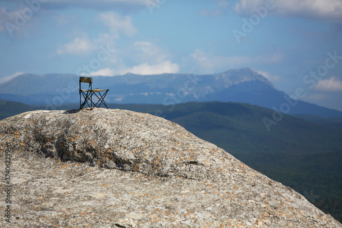 Breathtaking mountains view. Adventure travel. Summer vacations. Time to relax and dream. Chair on top of mountain #374062299