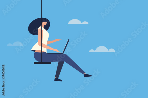 Girl sitting on a swing and working with laptop in an open sky. Concept for cloud computing