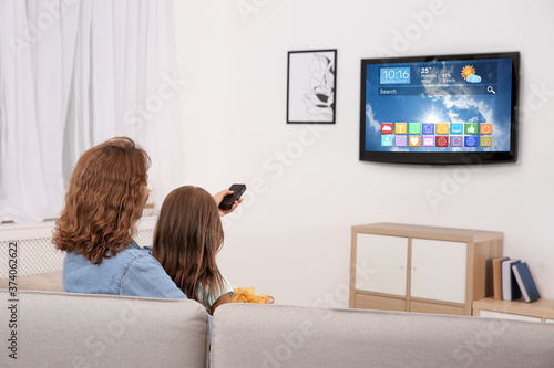 Mother and daughter watching smart TV in living room