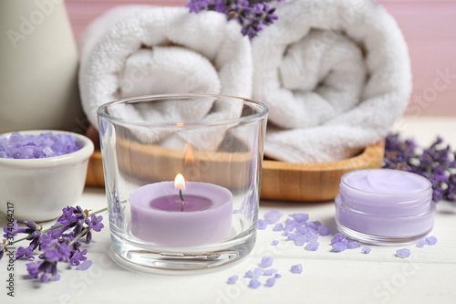 Cosmetic products and lavender flowers on white wooden table  closeup