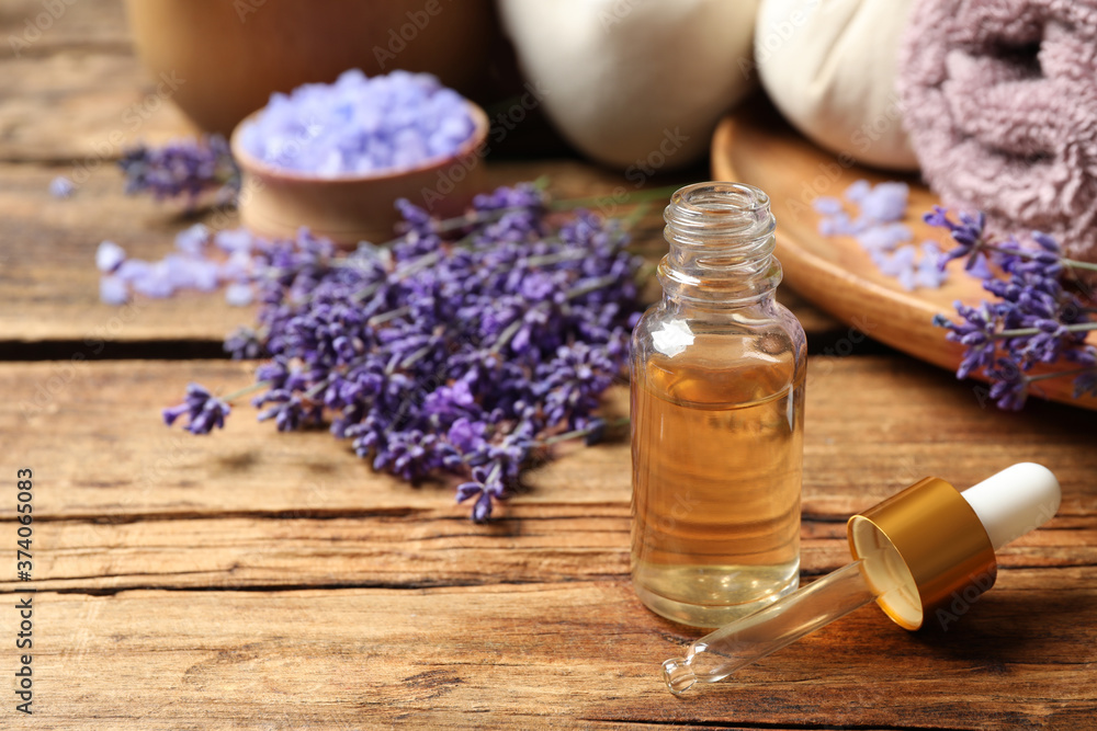 Composition with essential oil and lavender flowers on wooden table. Space for text Composition with essential oil and lavender flowers on wooden table. Space for text