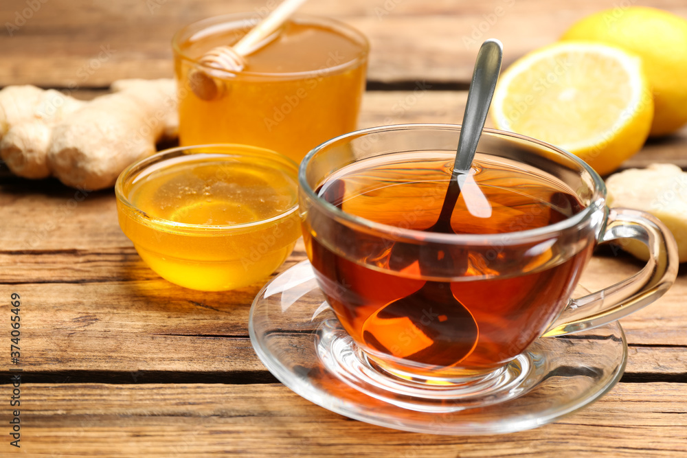 Tasty honey and tea on wooden table, closeup Tasty honey and tea on wooden table, closeup