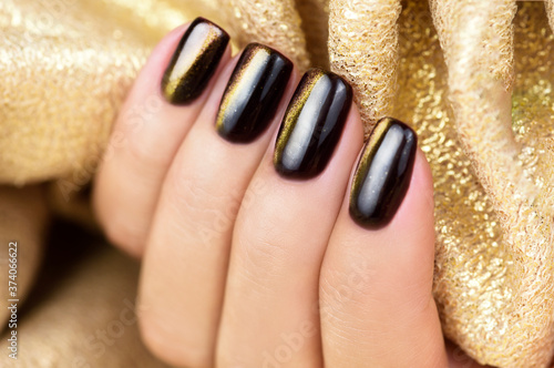 Cat Eye Nail Art. Manicure golden brown on a Gold background