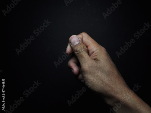 Male hand holding virtual card with fingers isolated on black background