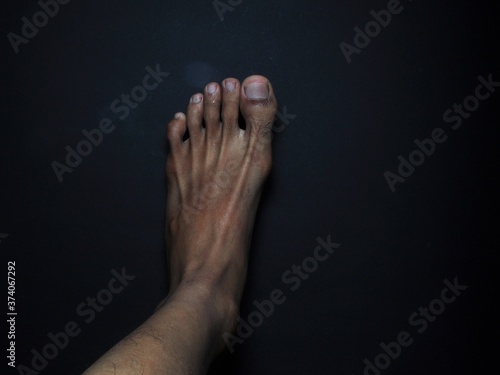 Close-up male feet isolated on black background
