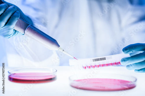 Close up of scientist working in the corona virus vaccine development laboratory research with a highest degree of protection gear. Coronavirus pandemic concept. Development of virus treatment drug.