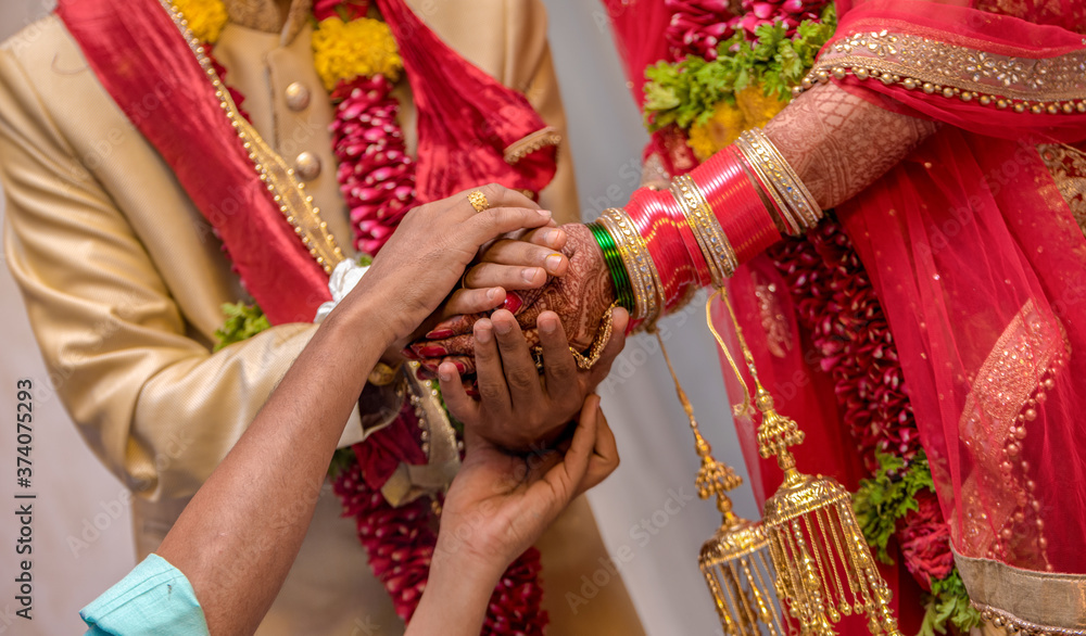 Very beautiful photo of traditional Indian wedding scene of Hindu family wherein priest is blessing the relationship of newly married couple as per vedic culture. Bride and Groom in ethnic dress. Pics
