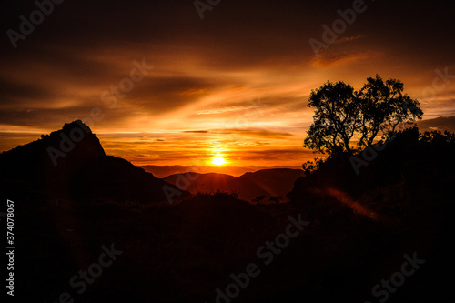 Sunrise in Minas Gerais. Idyllic landscape of mountains with dramatic sky and yellow sun resembling sunset and sunrise hour.