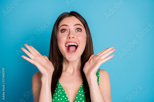 Closeup photo of attractive charming overjoyed lady raise arms up sly open mouth listen good news ecstatic winner wear green dotted tank-top singlet isolated blue color background