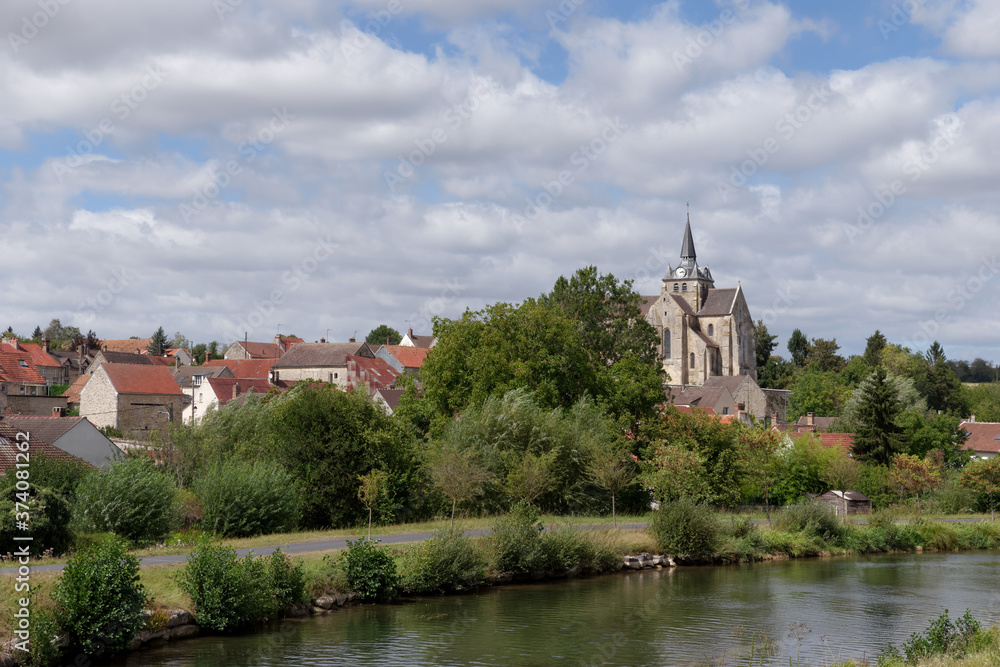 Church of Mareuil-sur-Ourc village and the Ourck canal in Ile-de-France region