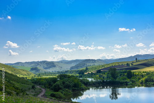 Landscape with hills and lake on a Sunny day, blue sky with clouds. Russia, Altai territory © Владимир Зубков