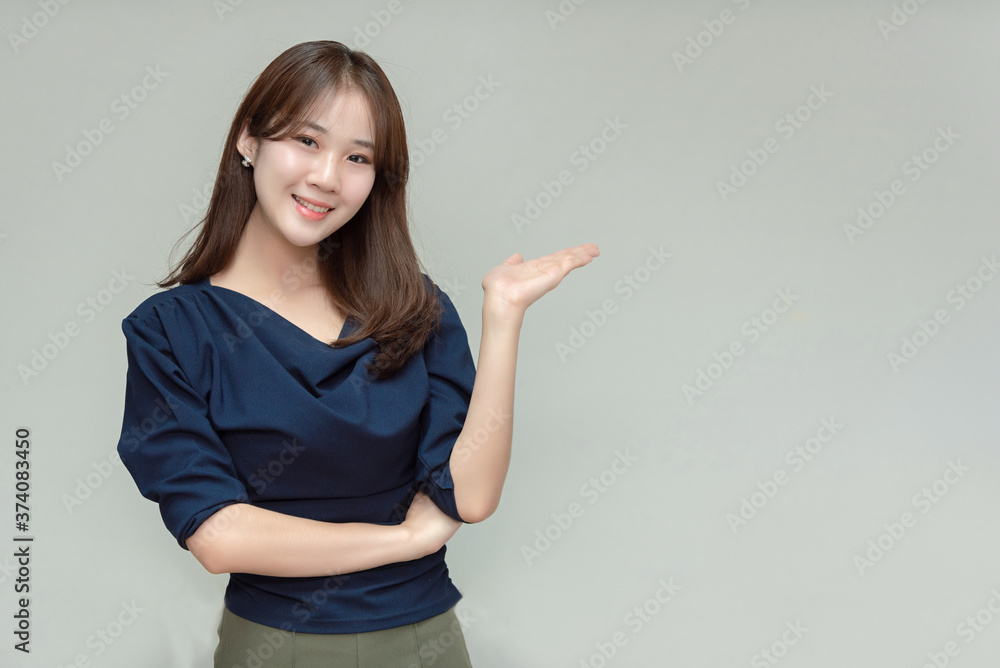 Asian business woman smiling and gesturing on gray background. Asian business woman smiling and gesturing on gray background.