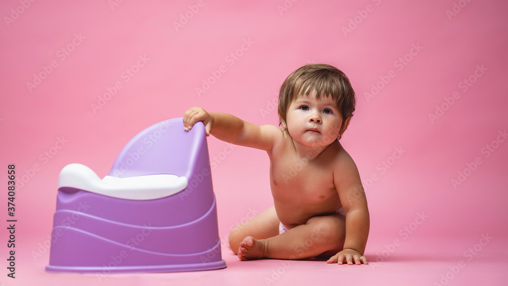 cute baby in a diaper is sitting next to a pot. Toilet and potty training. cute baby in a diaper is sitting next to a pot. Toilet and potty training.
